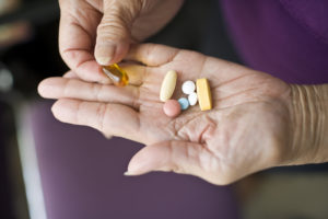 senior woman with a mix of prescription medications and herbal supplements