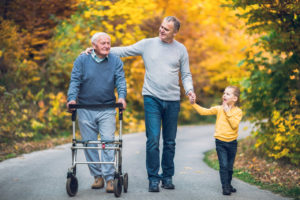 family walks with senior in a walker