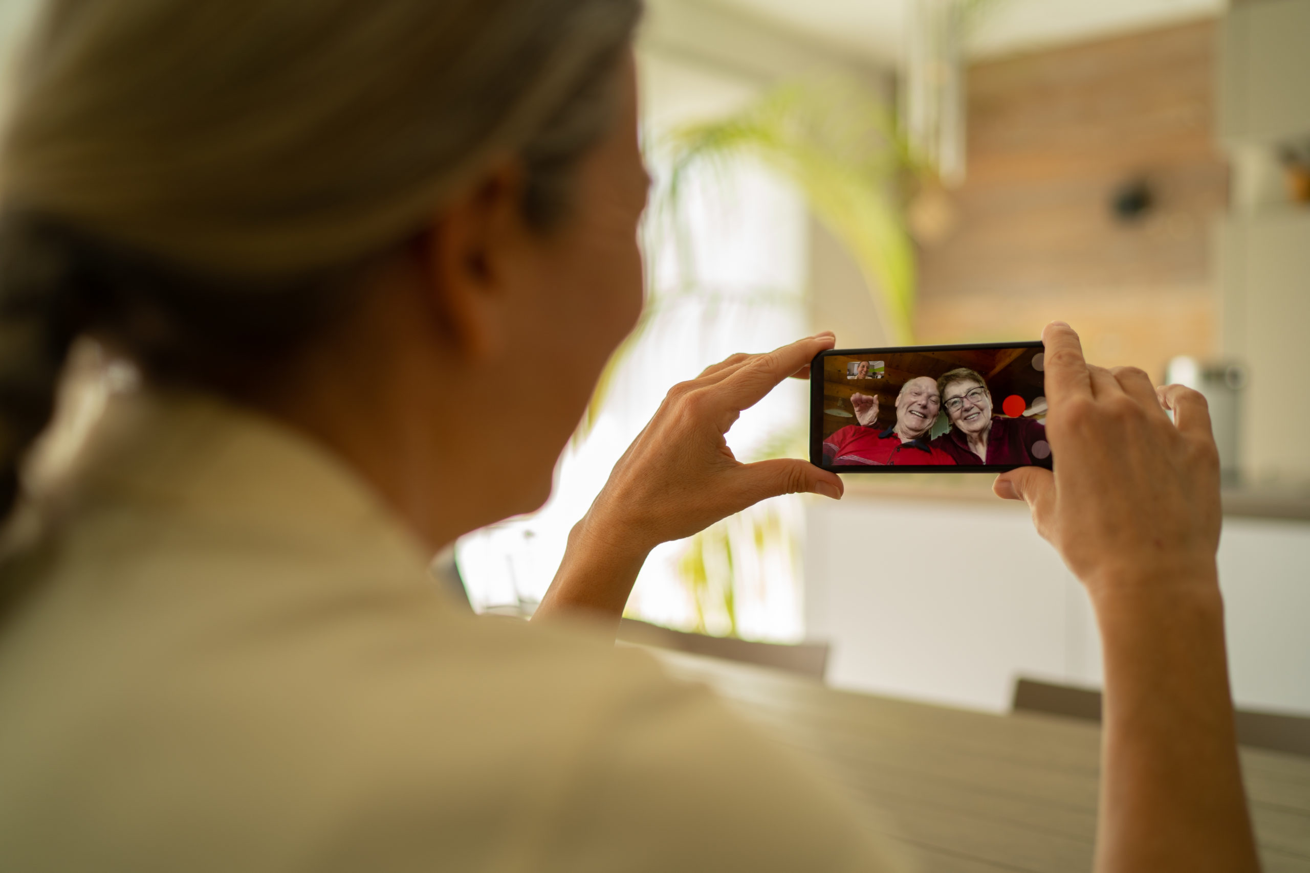 woman adult daughter connected with her senior parents through mobile phone video call during coronavirus crisis