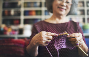 senior woman knitting a scarf