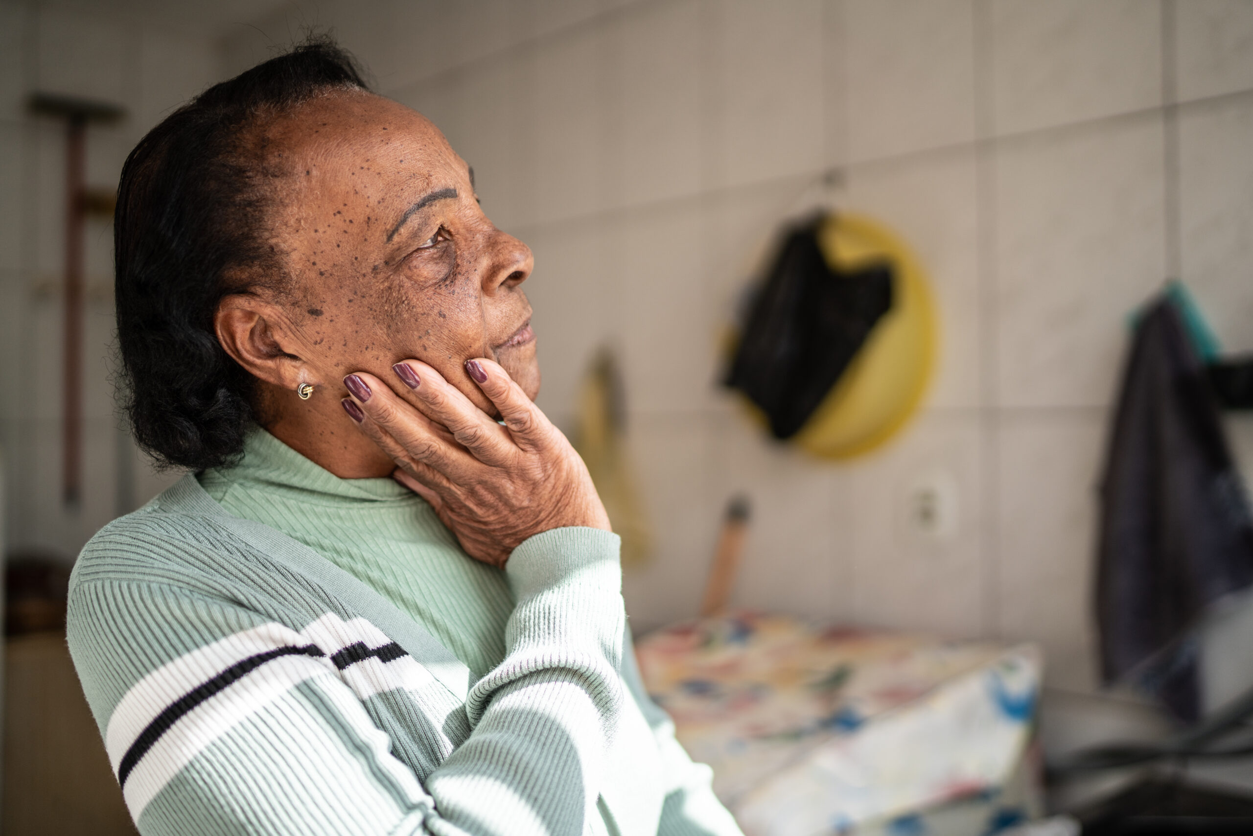 Contemplative senior woman looking away at home