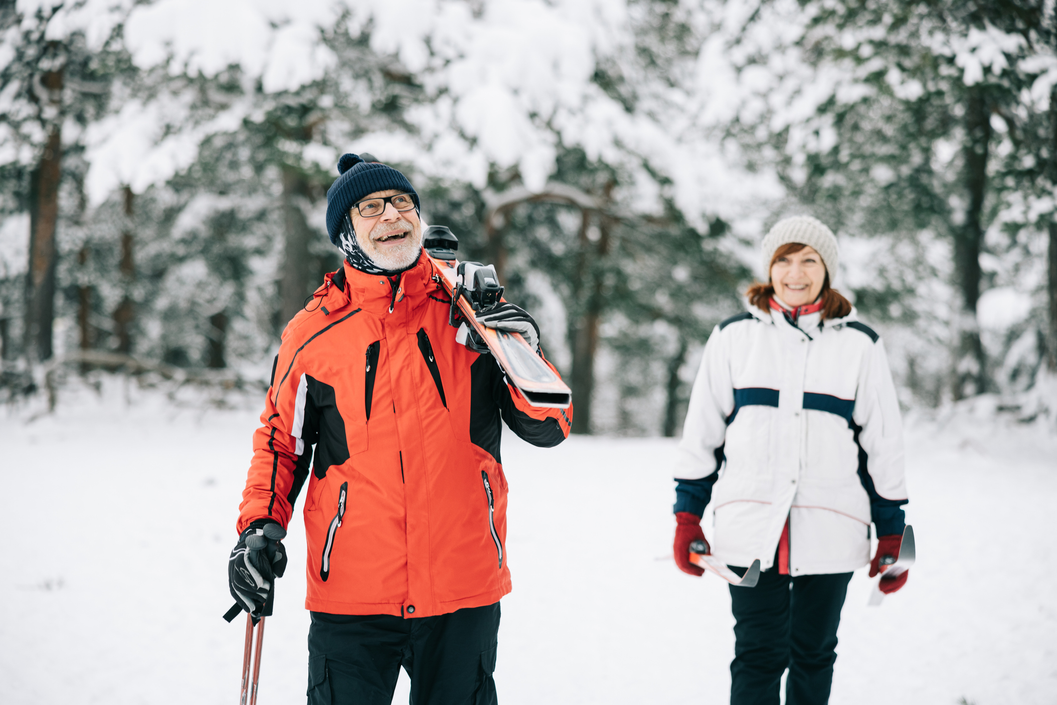 senior couple walking through snowy field